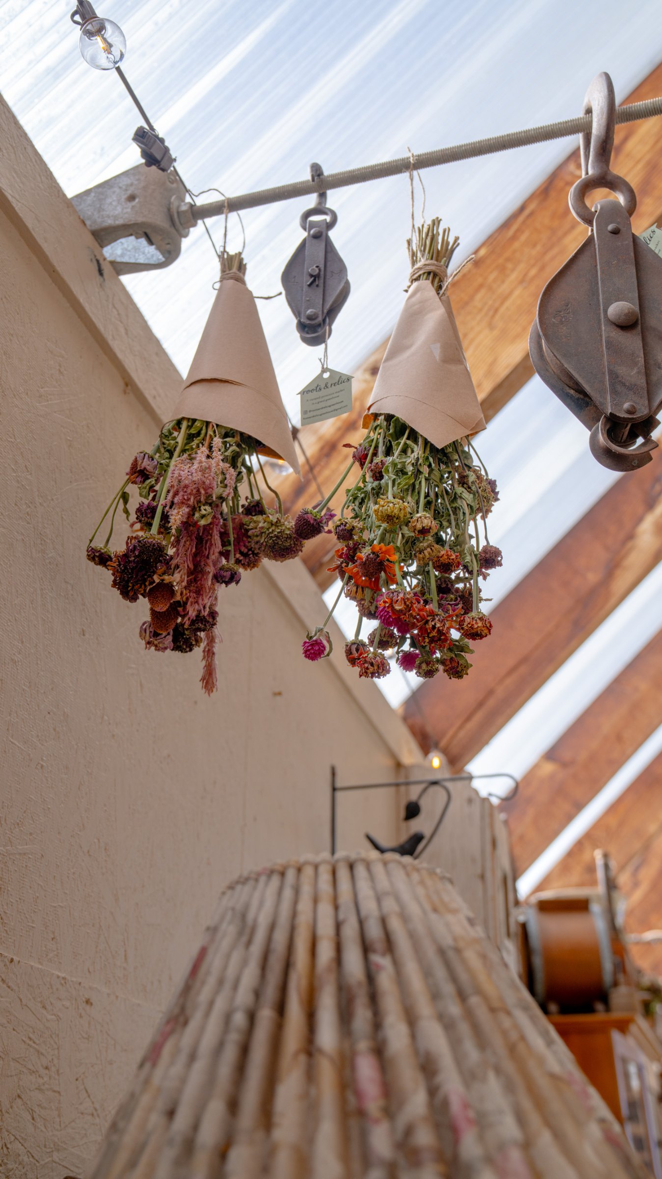 Floral decorations above a dress form under the rafters