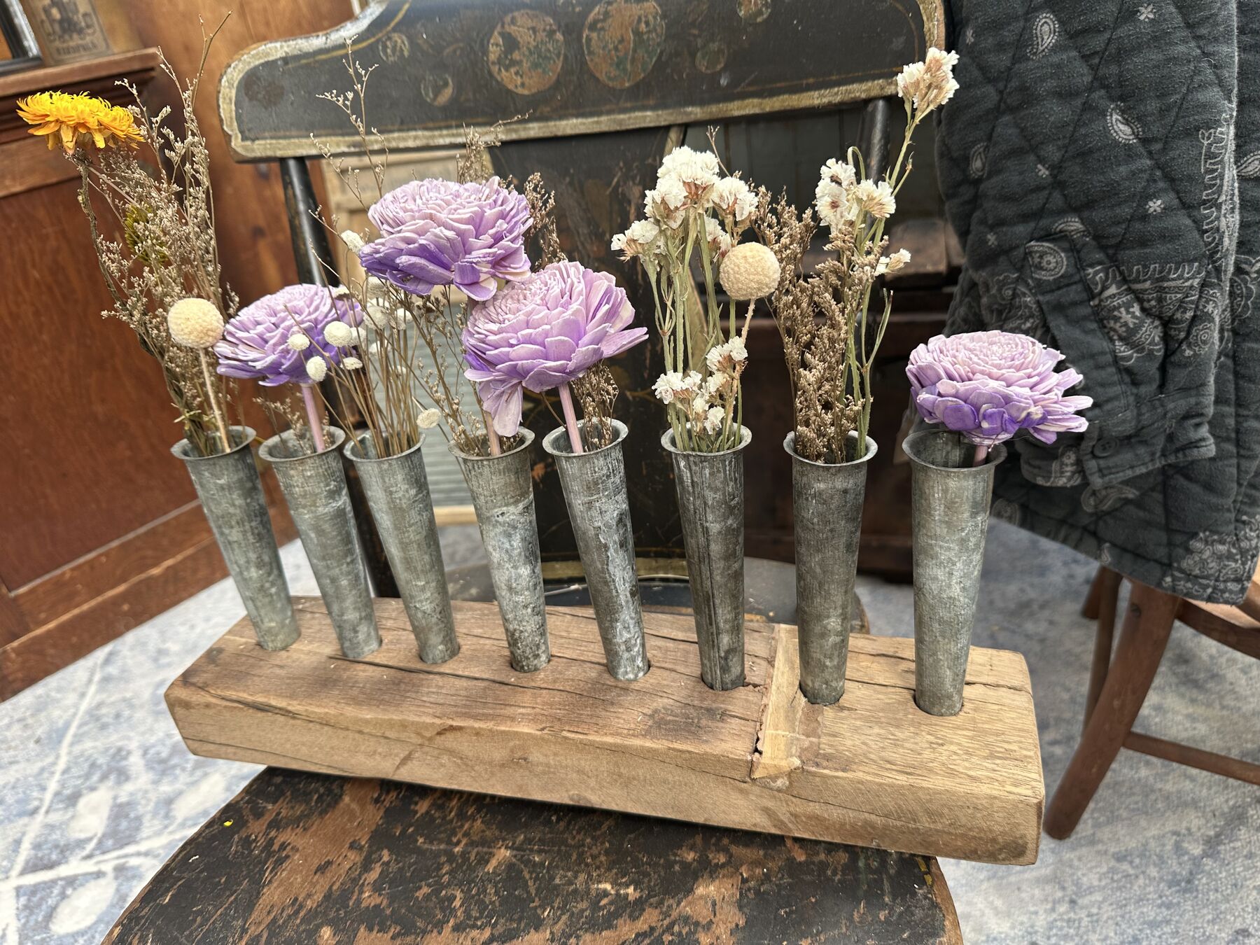 A small vintage metal flower holder filled with dried flowers