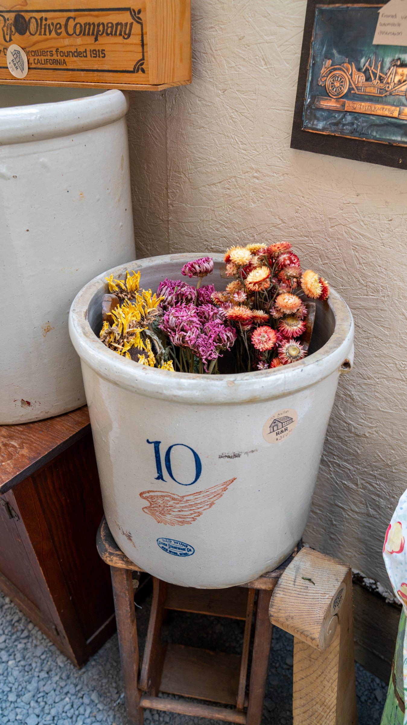 Autumn botanicals in a white crock on a wooden stand