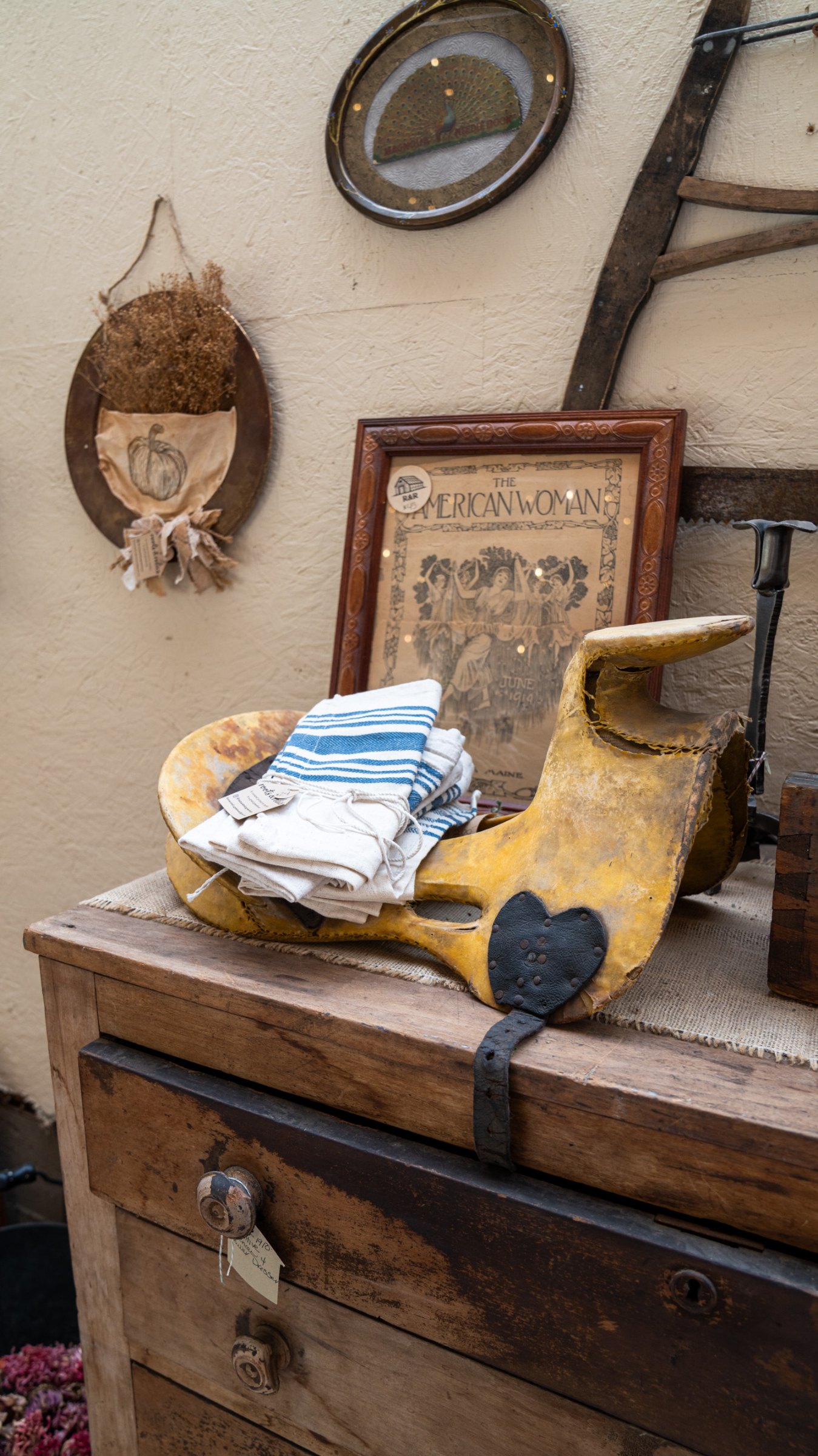 Wooden dresser displaying folded linens and a yellow chair