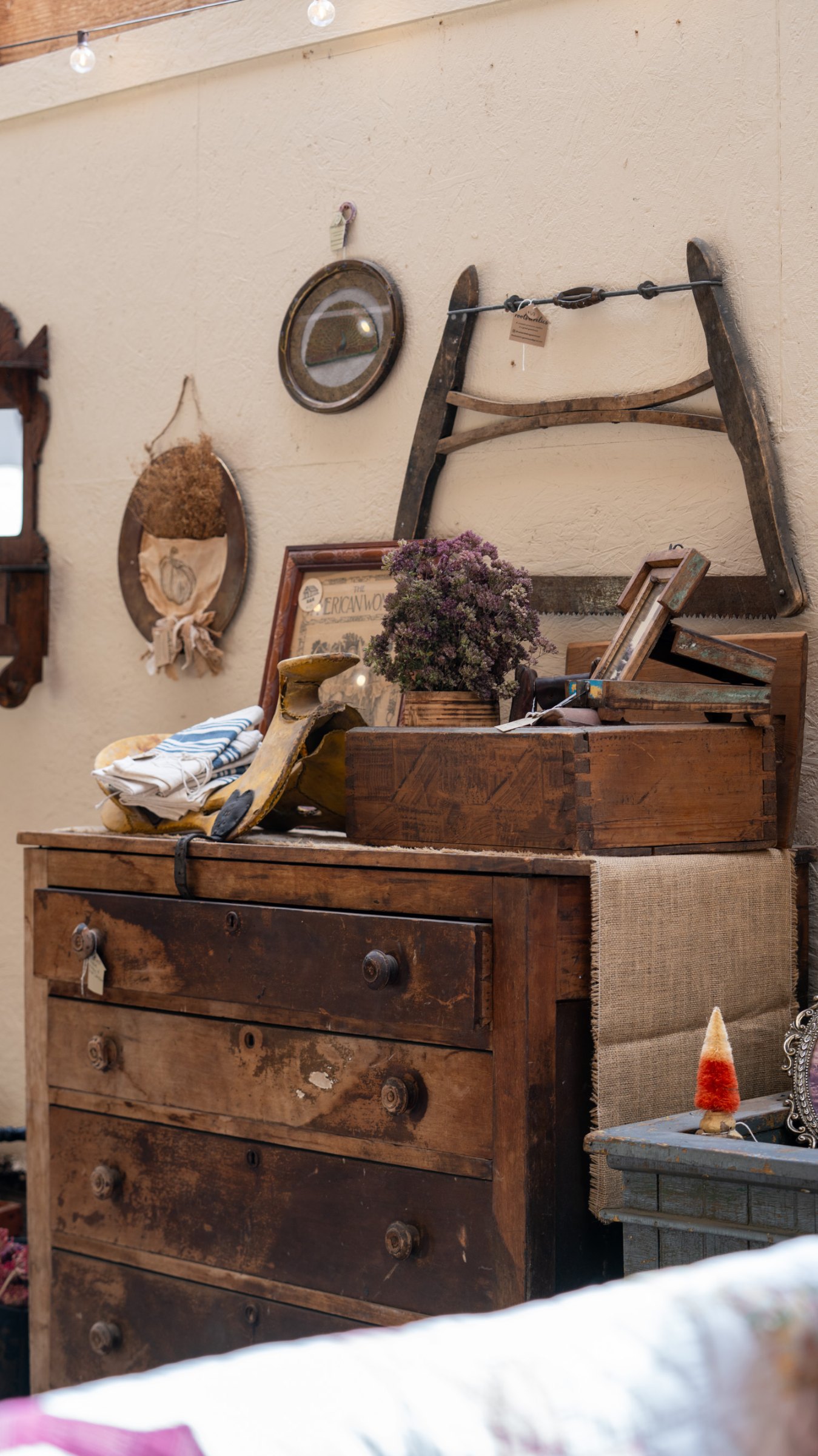 Antique wooden dresser beneath vintage wall decorations