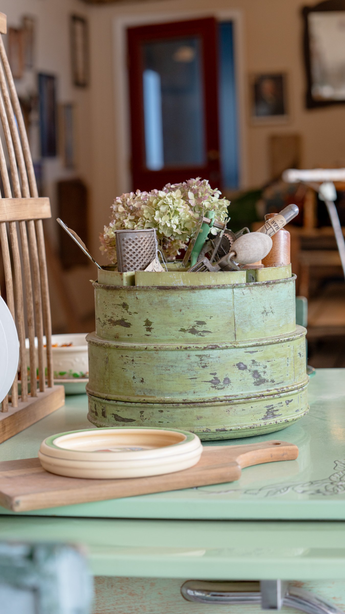 Green painted table with a wooden firkin and flowers
