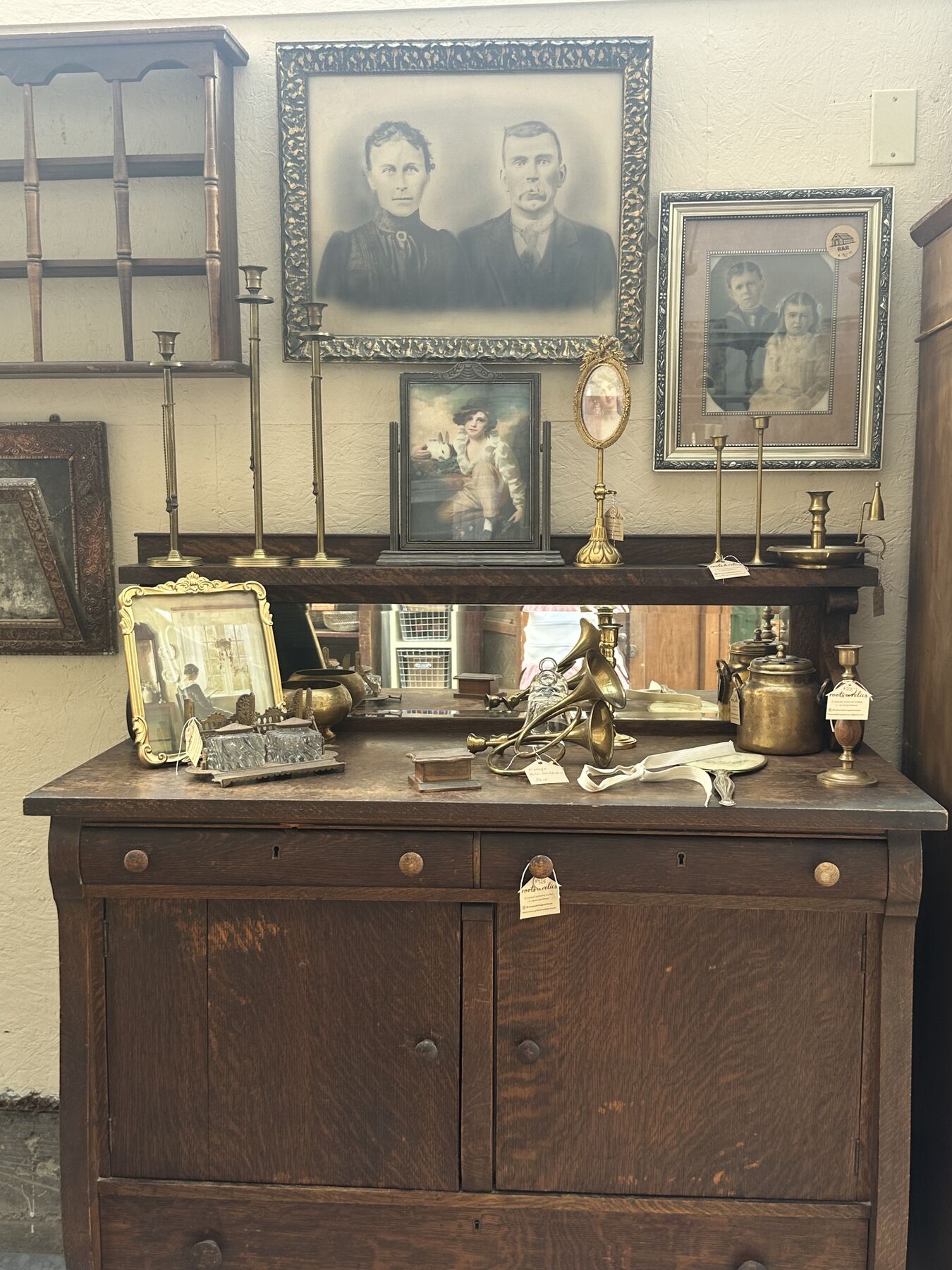 Old family portraits and collected objects displayed on an antique sideboard