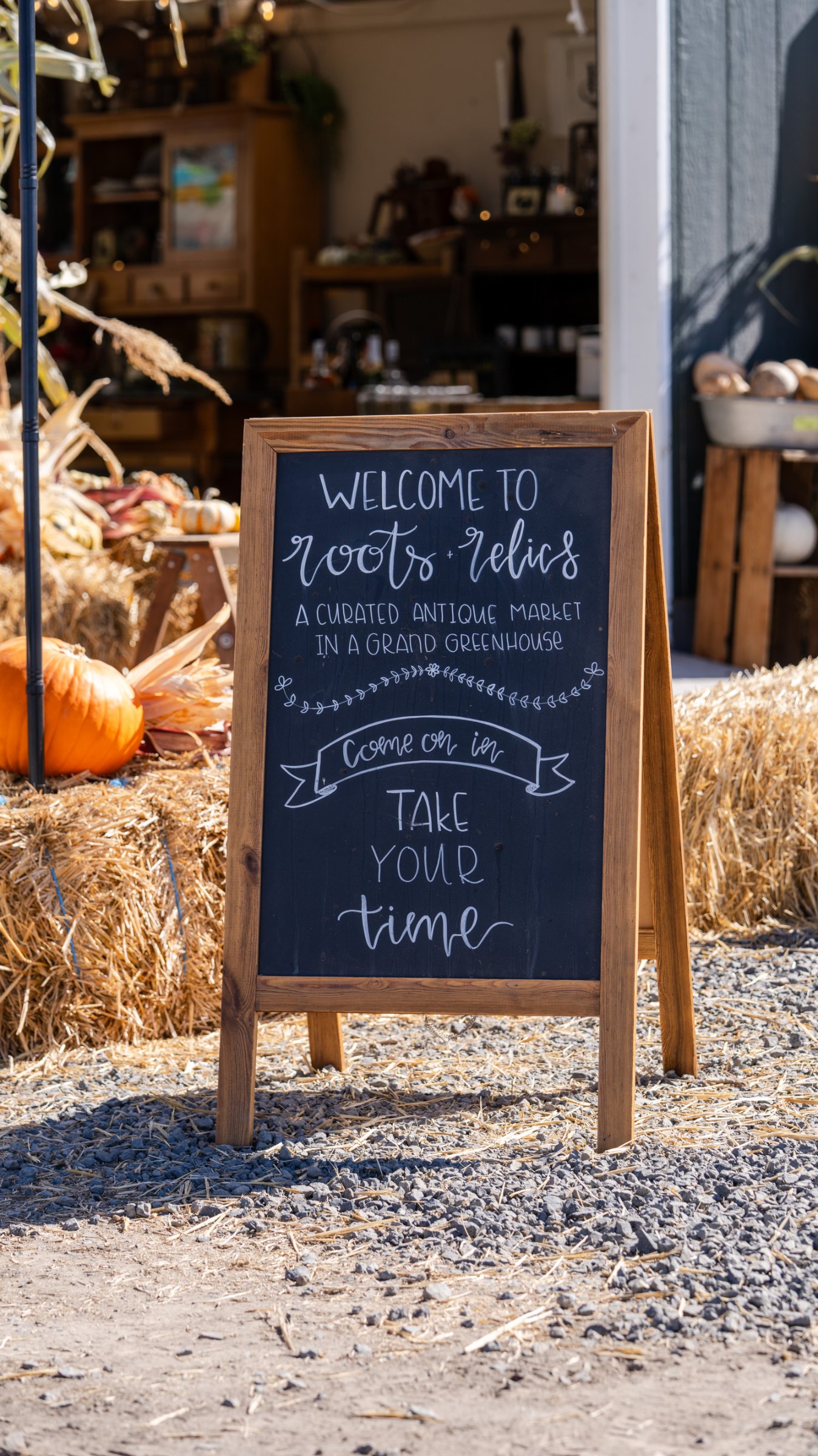 Welcome sign and pumpkins at the greenhouse doorway