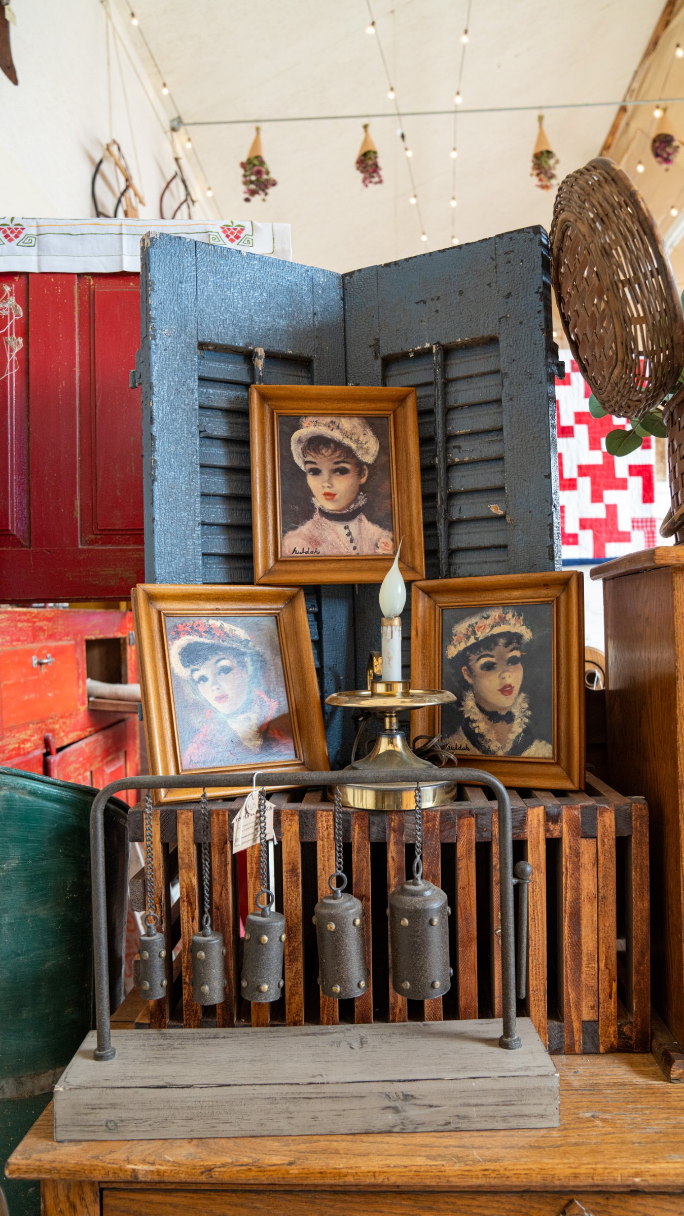 Framed portraits and vintage furnishings against red shutters