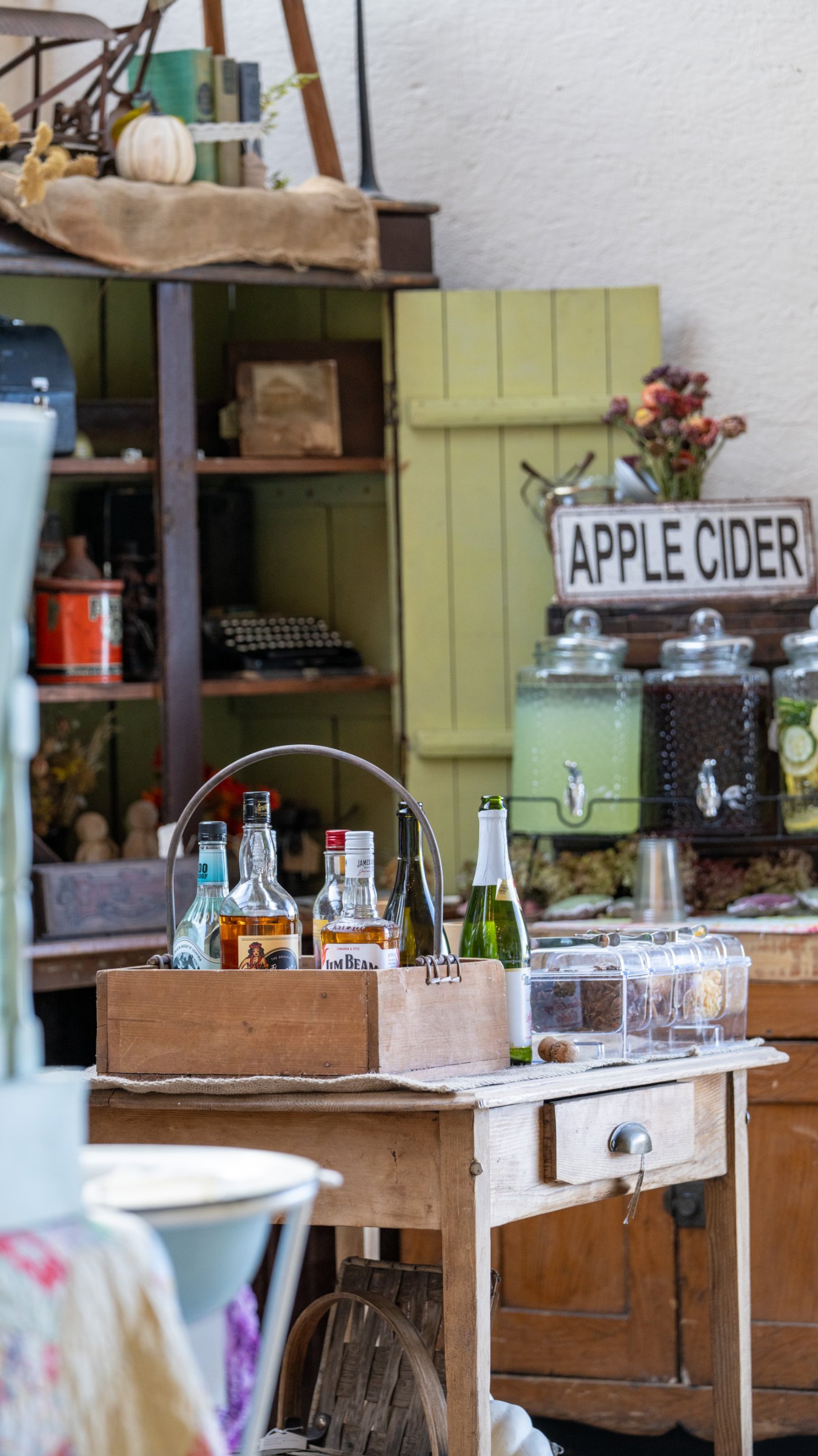 Apple cider station in a vintage green cabinet