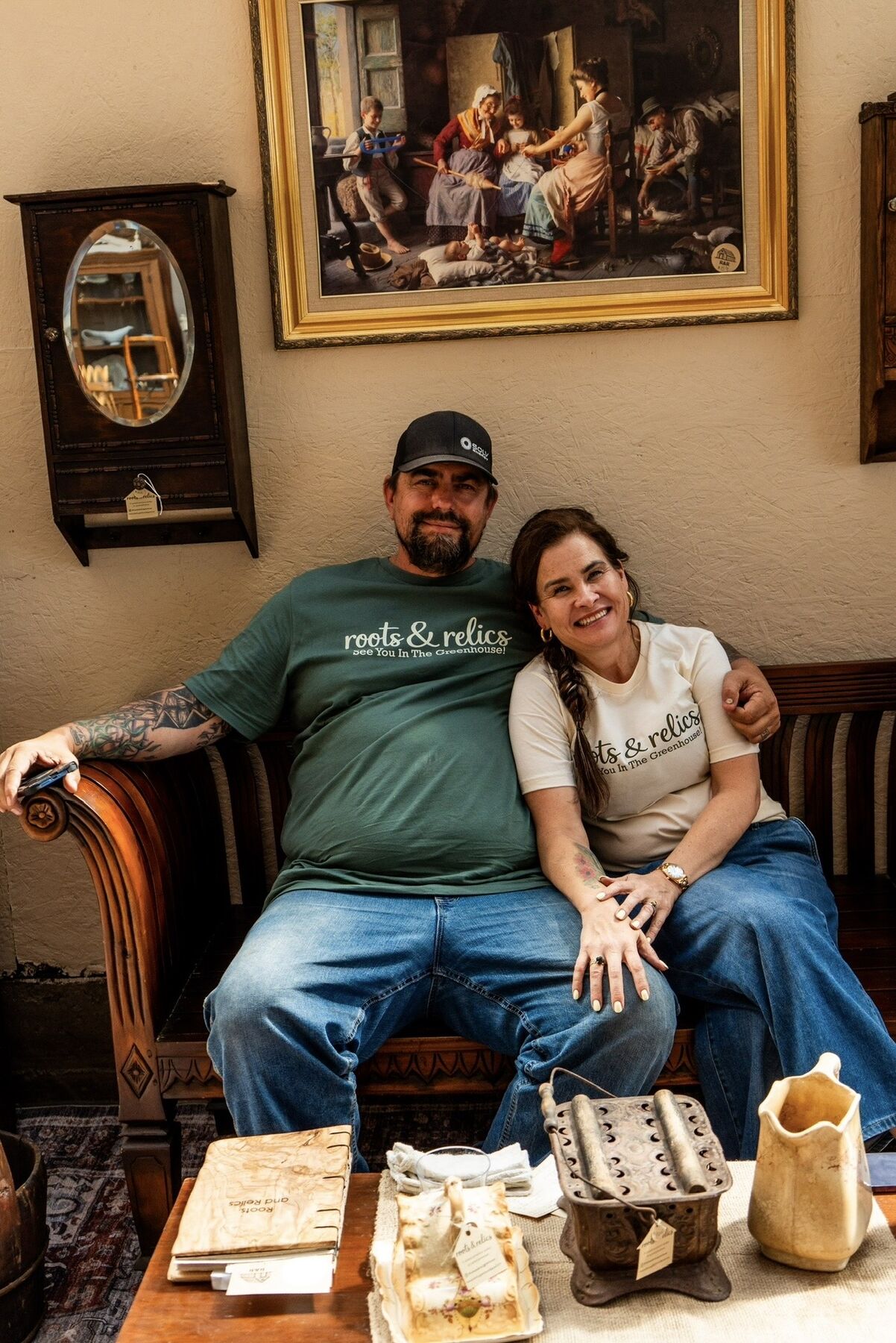 Pat and Jenn, founders of Roots and Relics, seated together in the greenhouse