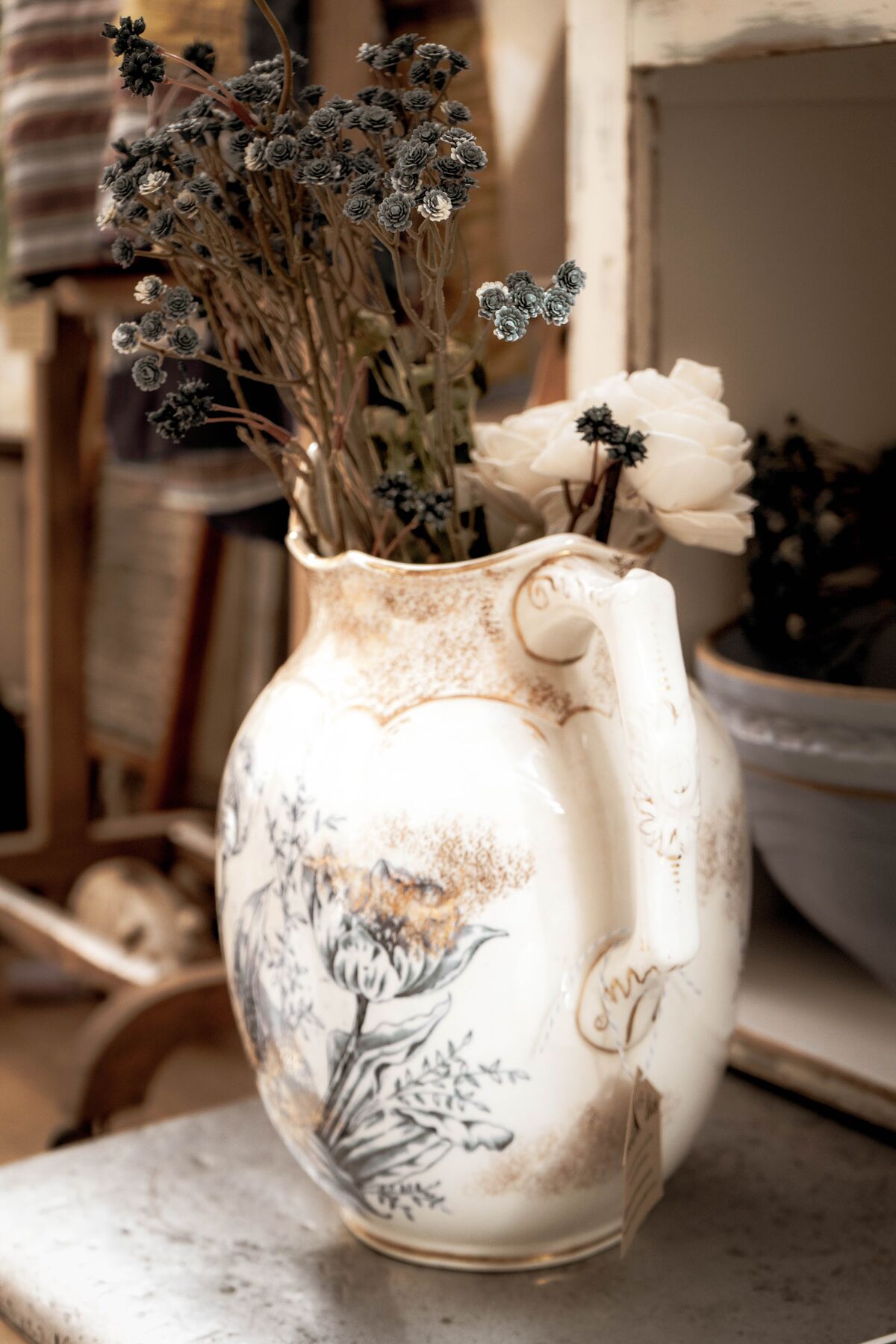 An antique ironstone pitcher holding gathered flowers