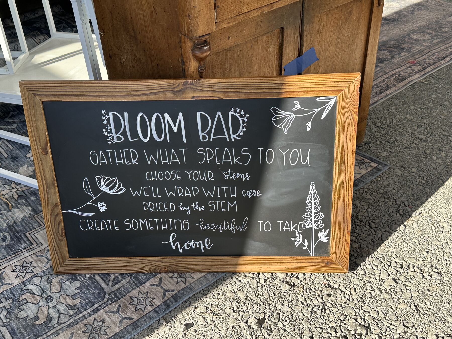 A hand-lettered bloom bar sign for a greenhouse gathering