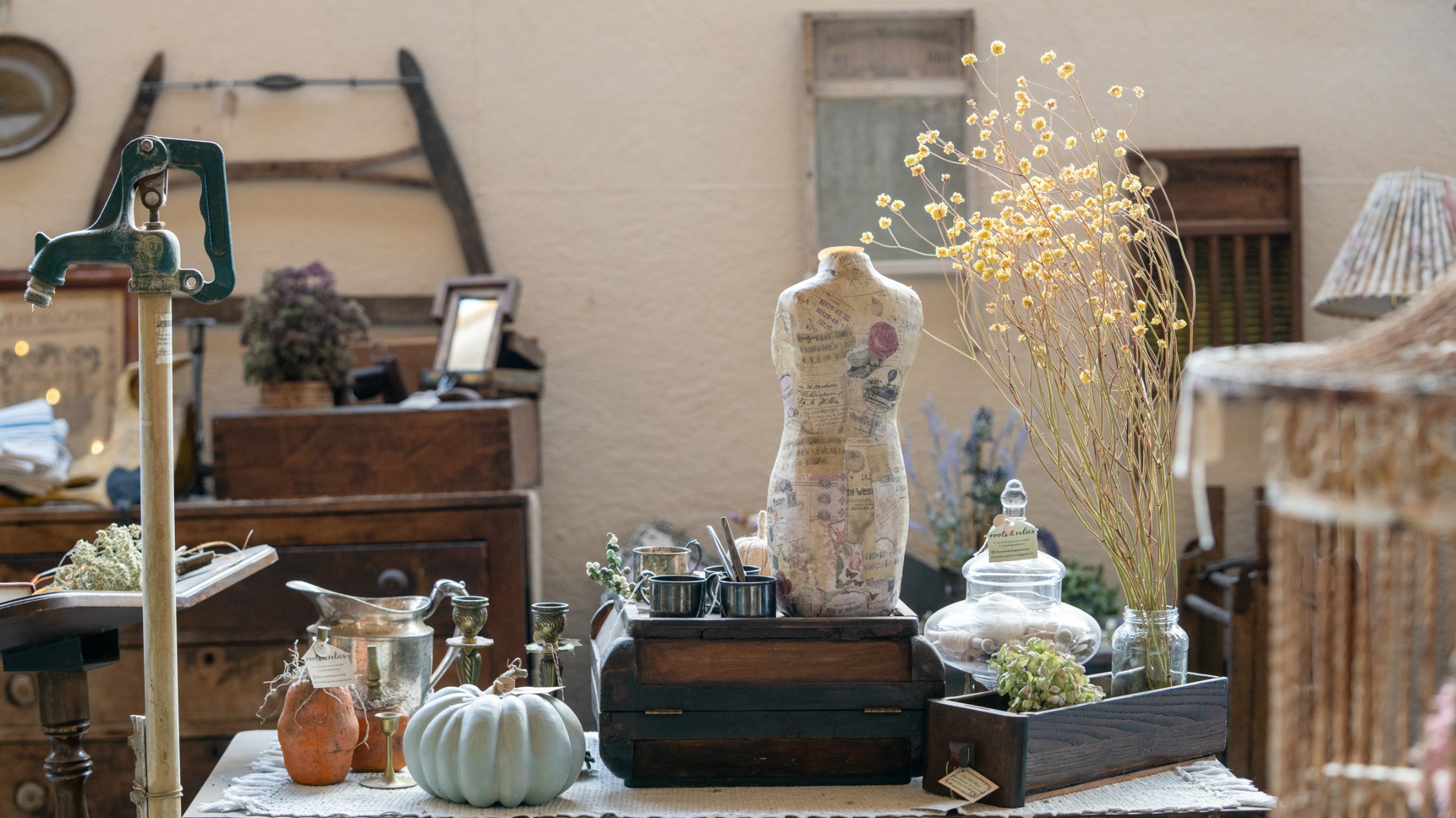 Vintage suitcases and glassware around a dress form