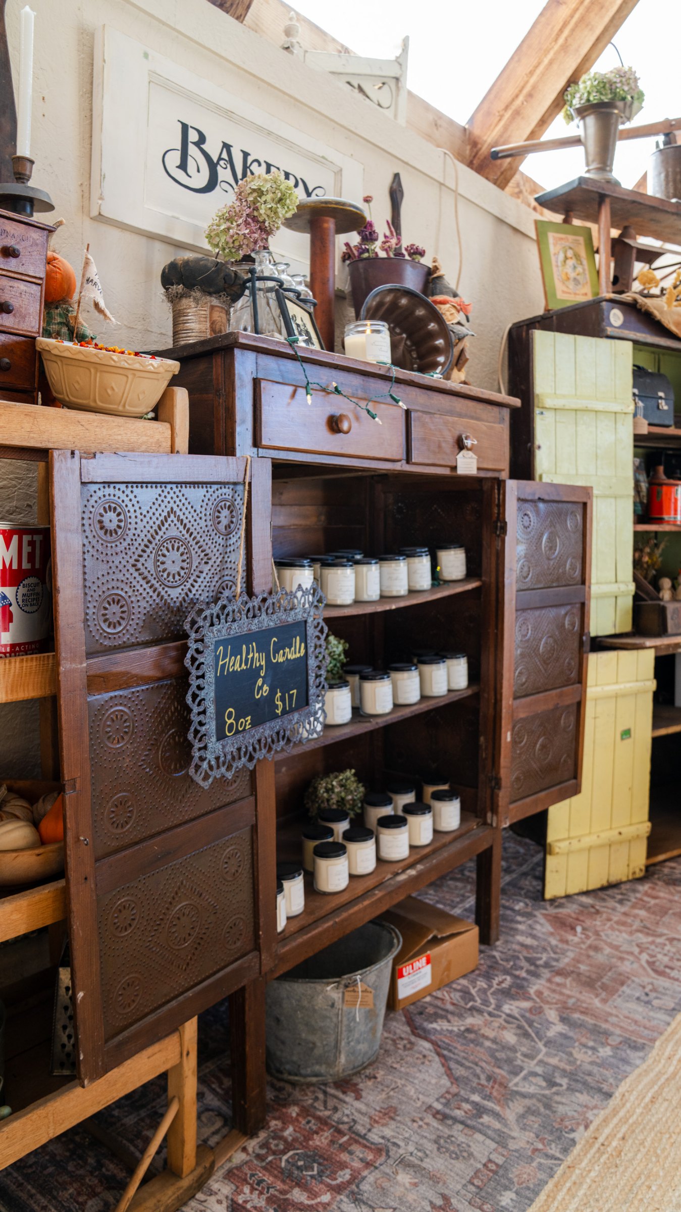 Wooden shelves filled with pottery, books, and antique finds